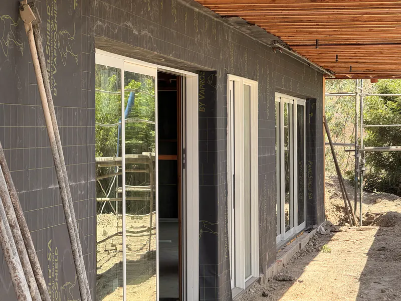 Air barrier detailed around door and window openings on a residential wall assembly