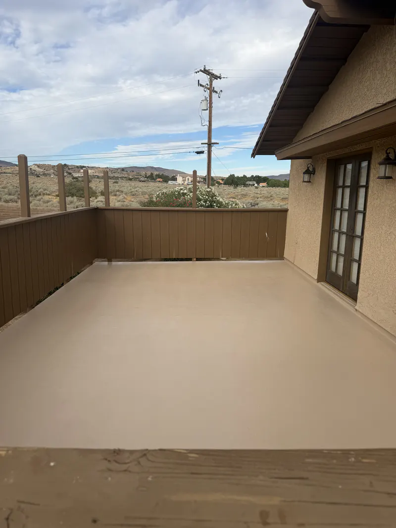 Completed deck coating on a rooftop patio, coved up the parapet walls