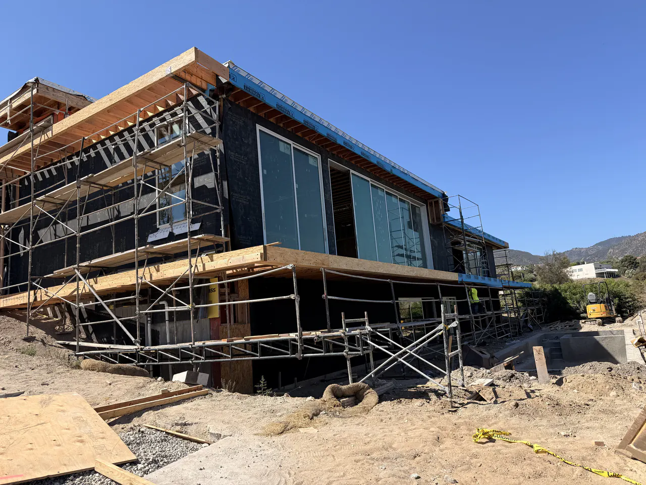 Modern custom home in Malibu wrapped and scaffolded for building envelope work