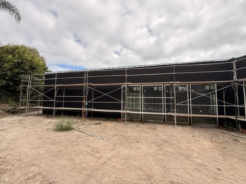 Full elevation wrapped in a weather resistive barrier with scaffolding still standing